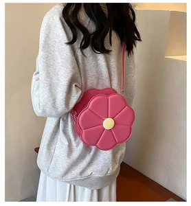 Détail du sac bandoulière rose en forme de fleur 3D avec un cœur jaune décoratif