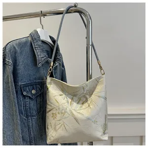 Close-up of hobo bag featuring elegant floral embroidery and slim leather strap