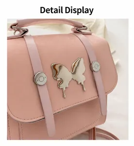 Close-up of pink backpack featuring large metal butterfly charm and magnetic closure