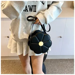 Détail du sac à bandoulière noir en forme de fleur avec un centre jaune décoratif