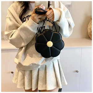 Détail d'un sac à main noir en cuir PU en forme de fleur avec un bouton jaune
