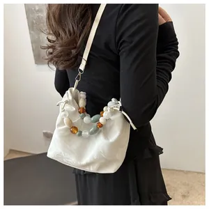 Detail of white marble print cloud bag with colorful acrylic beaded handle and drawstring