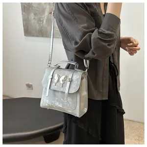 Close-up of metallic silver handbag with 3D butterfly hardware and textured finish