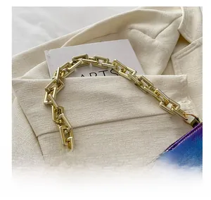 Detailed close-up of thick gold metal chain strap on iridescent laser leather shoulder bag