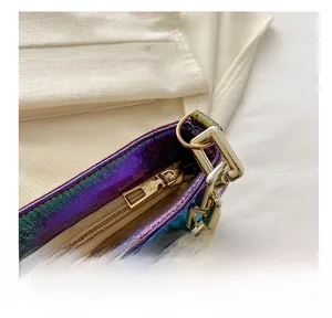 Detailed close-up of smooth gold zipper and chunky gold chain on gradient purple handbag