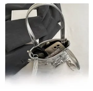 Internal view of the silver bow handbag showing phone, hair clips and cosmetics storage