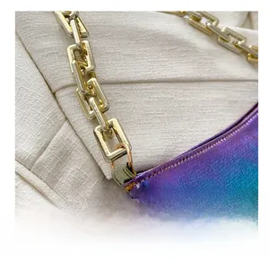 Close-up of golden metal rectangular chain link on holographic leather shoulder bag