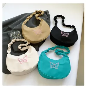 Detail of four colorful crescent underarm bags featuring elegant butterfly embroidery