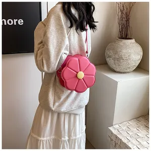 Détail d'un sac à bandoulière rose en forme de fleur porté par un mannequin