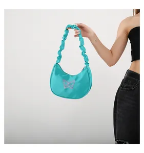 Detail of teal satin shoulder bag with pink butterfly embroidery and ruched strap