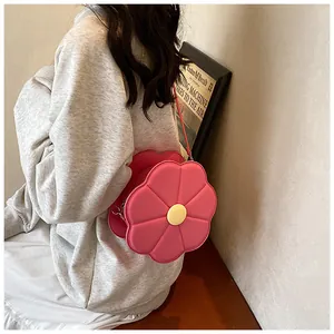 Vue détaillée d'un sac à bandoulière rose en forme de fleur porté par un mannequin