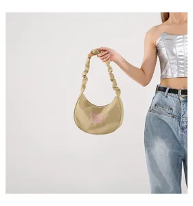 Close-up of khaki hobo bag with pink butterfly embroidery and pleated handle design