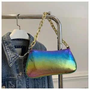 Detail of trendy metallic gradient underarm bag featuring a chunky gold chain strap