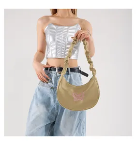 Detail of khaki shoulder bag with pink butterfly embroidery and pleated handle