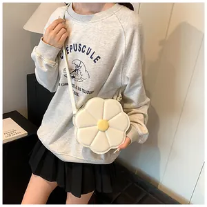 Vue détaillée d'un sac bandoulière blanc en forme de fleur avec des pétales matelassés