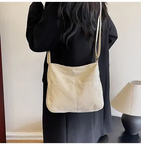 Detail view of the beige corduroy tote bag showing its ribbed texture and wide strap