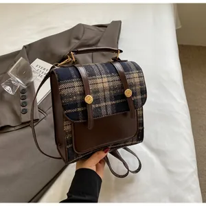 Mochila de estilo británico con patrón de cuadros y cuero marrón en ropa de cama
