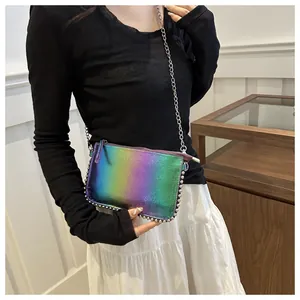 Detalle del bolso bandolera holográfico con remaches plateados y correa de cadena