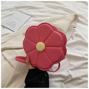 Détail d'un sac bandoulière rose en forme de fleur avec matelassage et centre jaune vif