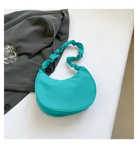 Detailed view of tiffany blue crescent bag with a pleated scrunchie shoulder strap
