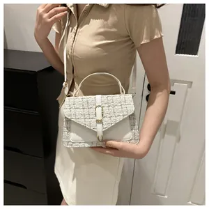 Dettaglio patchwork in tweed e pelle crema su borsa a tracolla con chiusura in oro