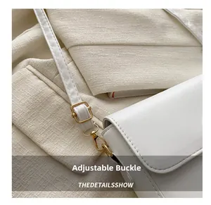Detail view of adjustable golden buckle and high-quality leather strap on white square bag