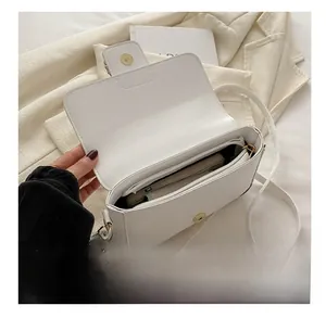 Top view of white square crossbody bag showing internal capacity and metal clasp
