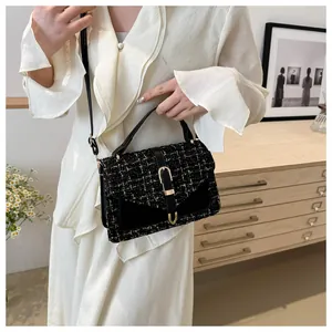 Dettaglio della borsa a tracolla in tweed con fibbia dorata a U e tracolla nera elegante