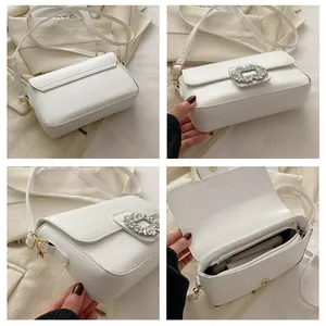 Detail view of white square bag with rhinestone buckle and interior phone pocket