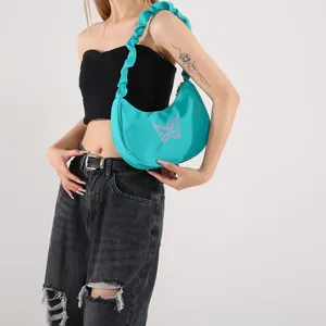 Bright blue crescent shoulder bag with pink butterfly embroidery and ruffled strap