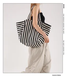 Detail of large striped tote bag featuring classic black and white canvas patterns