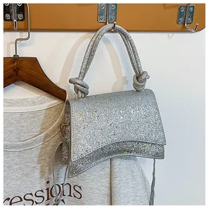Détail du sac à main pailleté argenté avec poignée nouée et texture brillante unique