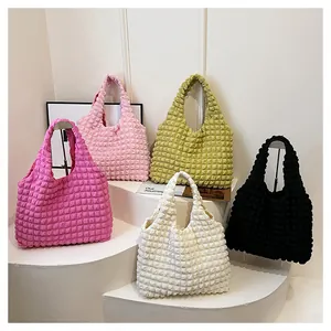 Détail de texture bulle sur les sacs fourre-tout en rose, vert, noir et blanc