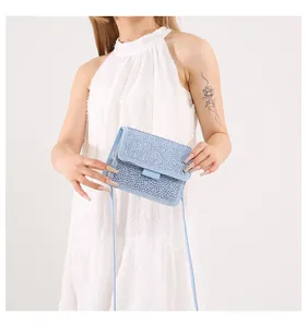 Dettaglio mini borsa azzurra con strass scintillanti e tracolla in pelle di alta qualità