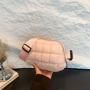 Borsa a tracolla in nylon trapuntato rosa con tracolla regolabile in un ambiente moderno