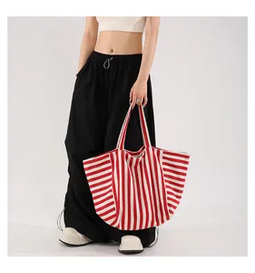 Detail of red and white striped canvas tote bag showing large capacity and vibrant texture