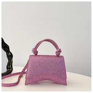 Détail du sac à main pailleté avec base incurvée et poignée à motif noué chic