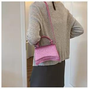 Détails du sac rose pailleté montrant la base incurvée et la poignée nouée