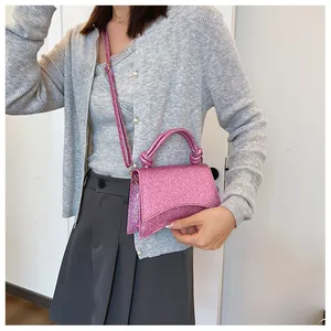 Détail du mini sac rose scintillant avec poignée nouée et base incurvée élégante