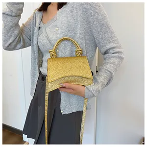 Détail du sac à main à paillettes dorées avec poignée nouée et texture scintillante