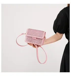 Dettaglio borsa rosa con strass che mostra cristalli brillanti e trama della tracolla