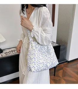 Détail du sac bandoulière en toile avec imprimés fleurs violettes et jaunes sur la sangle