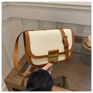 Detail view of canvas and brown leather stitching on a vintage saddle shoulder bag