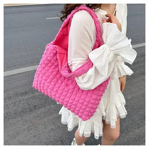 Détail d'un sac cabas rose avec texture popcorn et motif à bulles 3D en tissu élastique