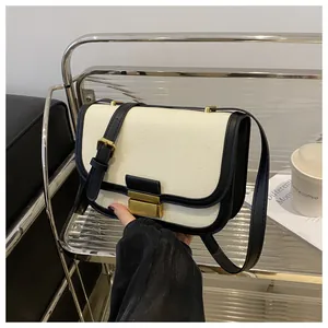 Detail of vintage canvas and black leather crossbody bag with elegant gold metal buckle