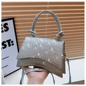 Détail du sac à main à paillettes argentées avec poignée nouée et bandoulière réglable
