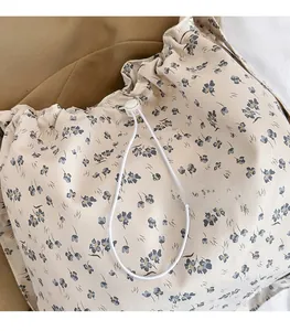 Détail du sac en toile à fleurs montrant le cordon de serrage et la texture du tissu