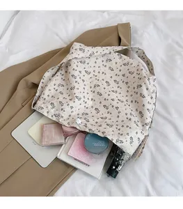 Détail du sac en toile fleurie montrant une grande capacité pour tablette et objets