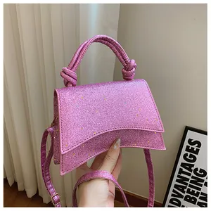 Gros plan détaillé des paillettes roses et de la poignée nouée sur ce sac à main incurvé