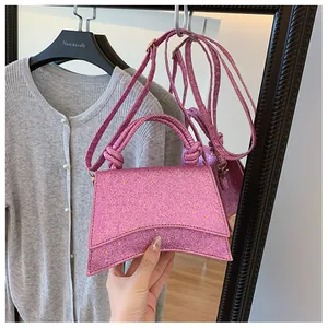 Détail du mini sac à main pailleté rose avec poignée nouée et design géométrique